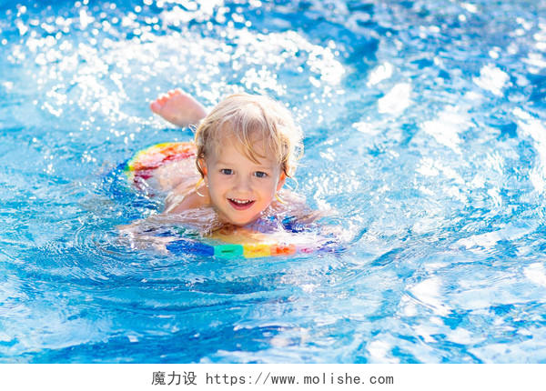 孩子们在热带旅游胜地的室外游泳池里学习游泳亲子游泳